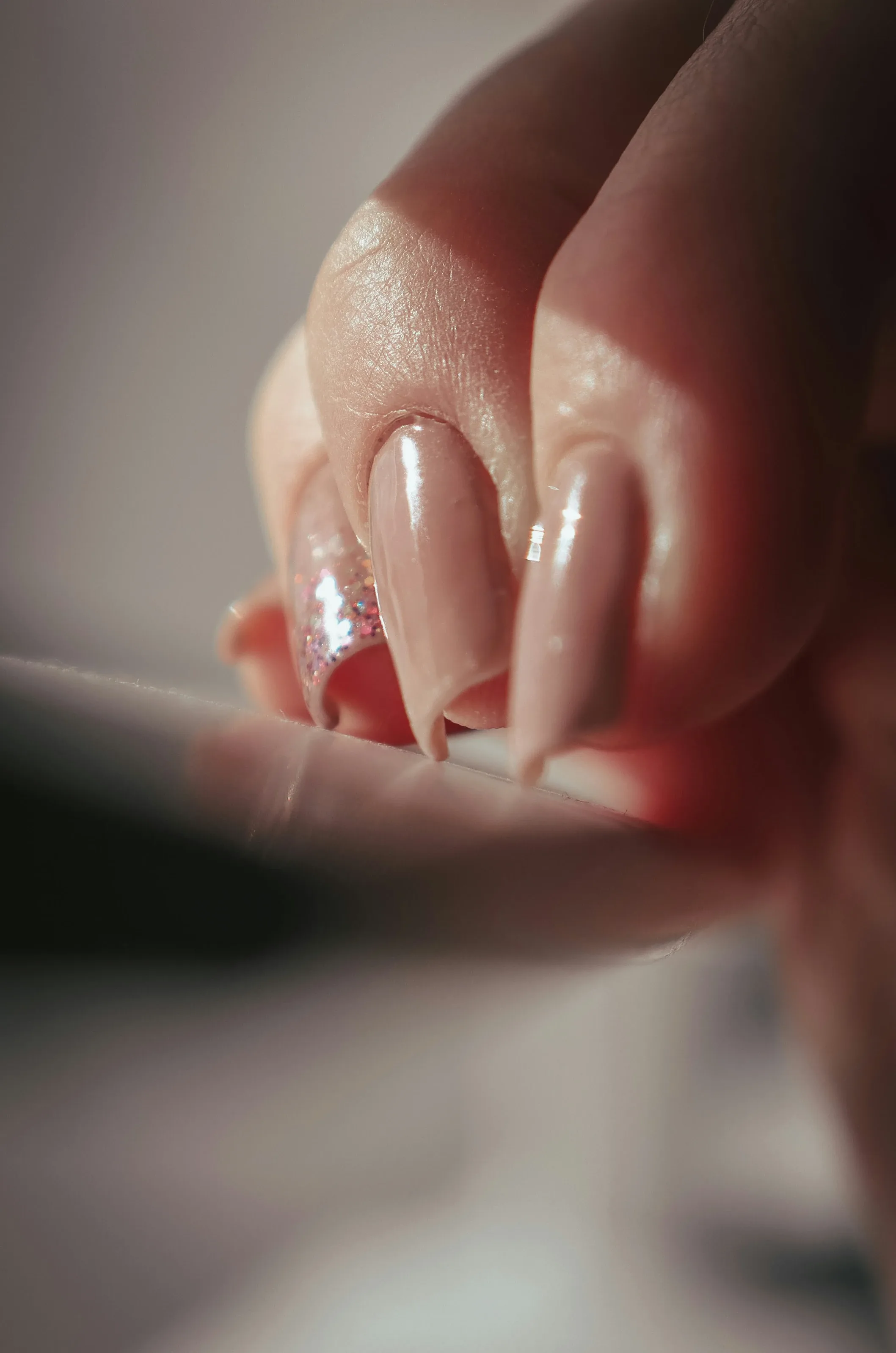 Macro close-up showing the smooth curved apex and mirror shine of a nude gel overlay
