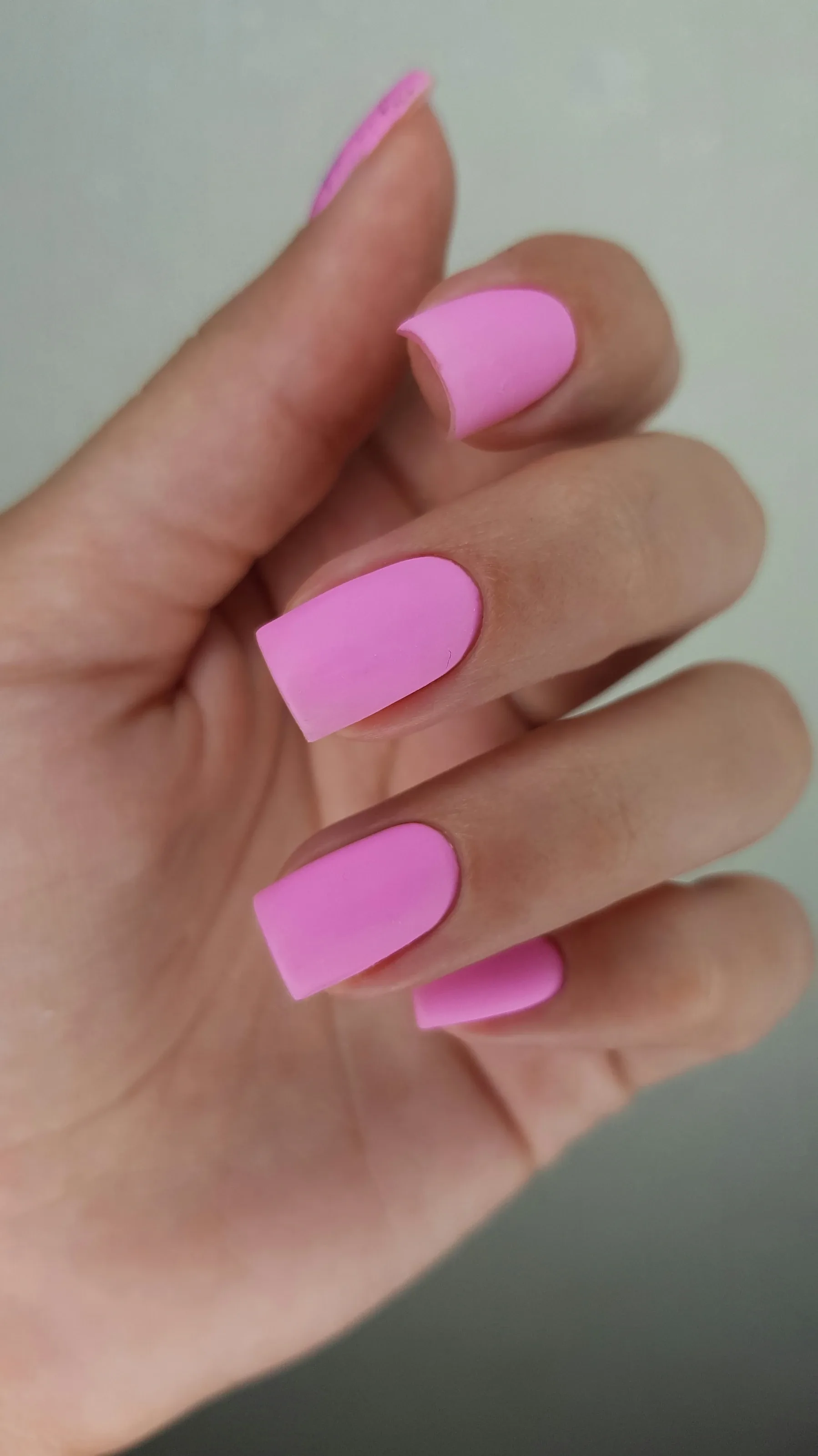 Square manicured nails finished in a soft rose blush