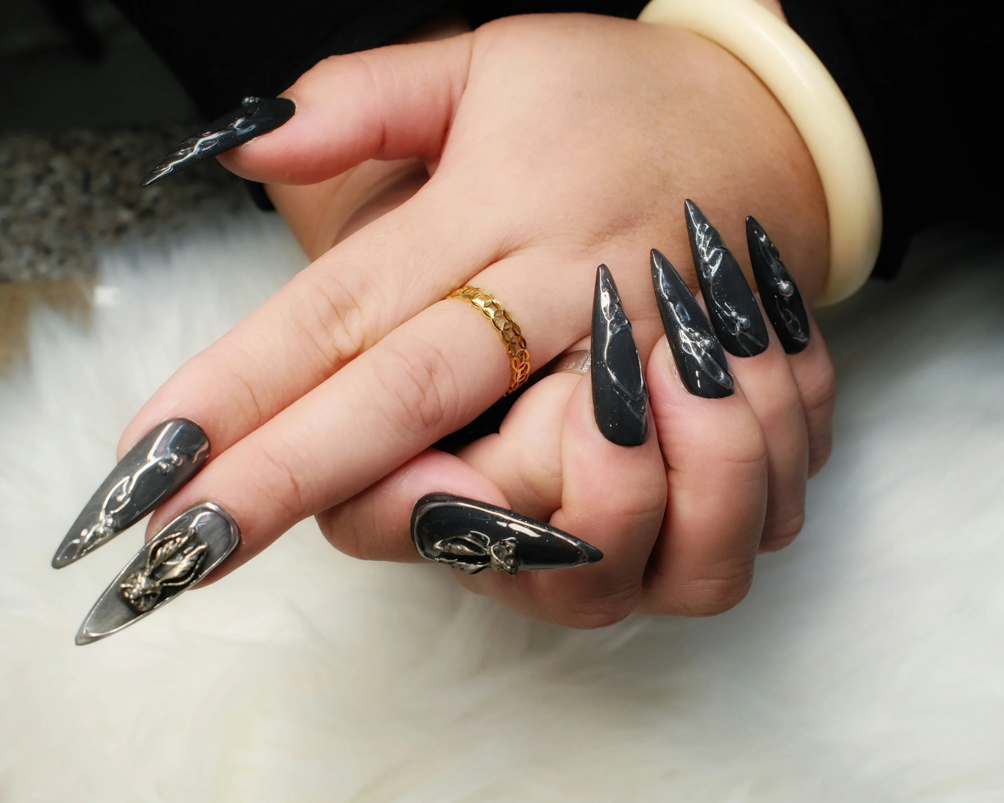 Long sculpted stiletto extensions in glossy black with silver chrome line art