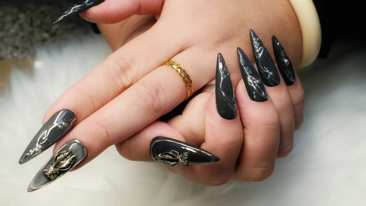 Long sculpted stiletto extensions in glossy black with silver chrome line art
